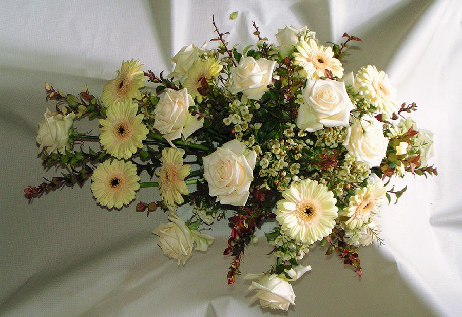 A soft arrangement of white roses and gerbera daisies